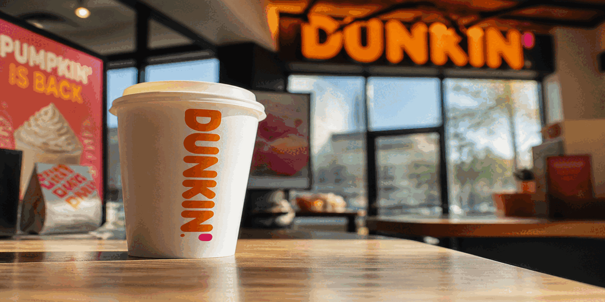 Dunkin' logo displayed on modern coffee cup and storefront signage